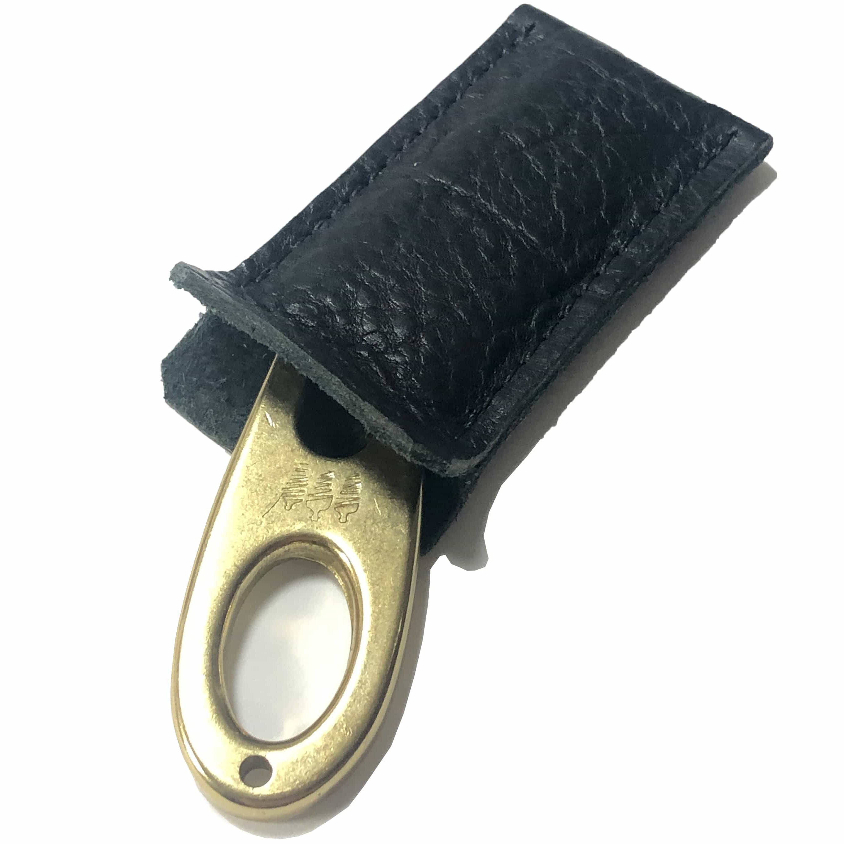 Golf divot tool solid brass with black bison leather sleeve, shown inserted.