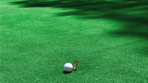 Divot tool with golf ball on grass background