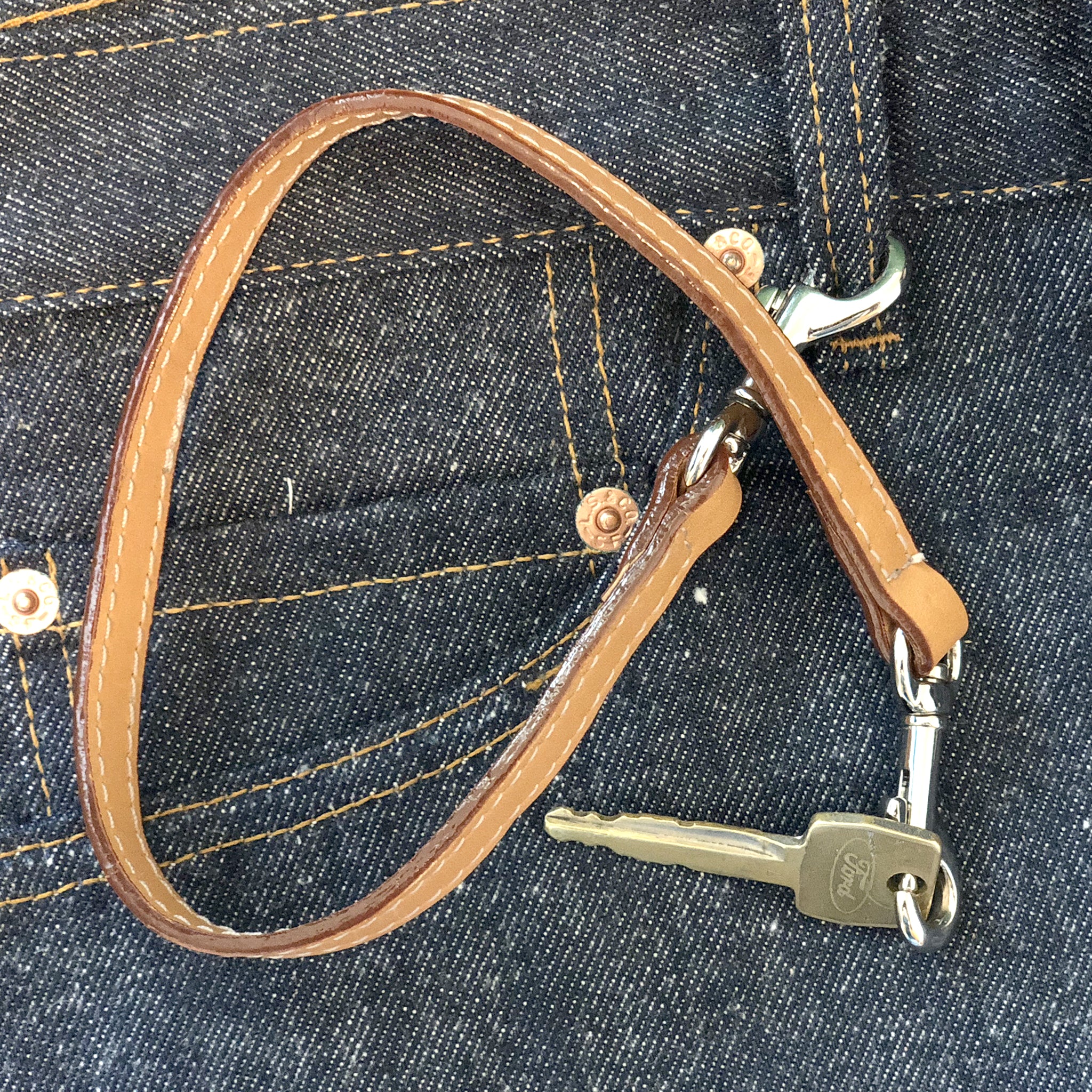 Leather key lanyard in saddle tan attached to Levis belt loop